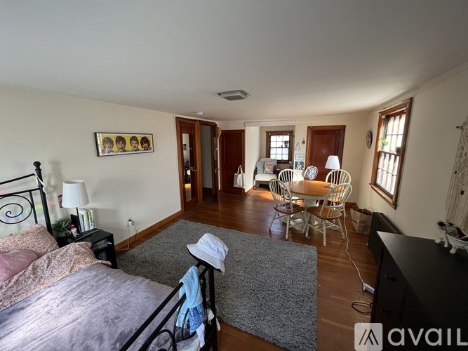 A bedroom with a bed, dresser, and a chair.