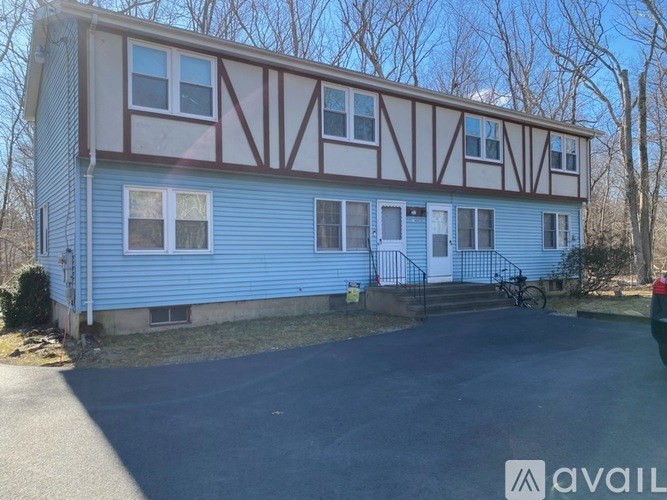 A blue house with a white door and a bicycle parked in front.