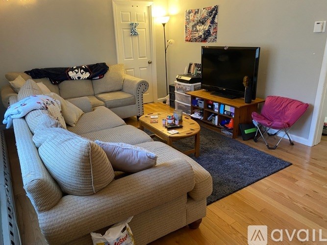 A living room with a couch, a chair, a coffee table, and a television.
