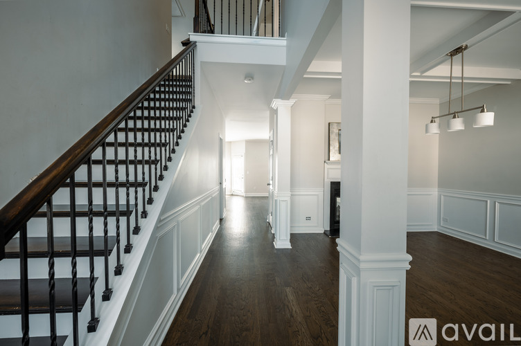 A spacious hallway with a staircase on the left and a doorway on the right.