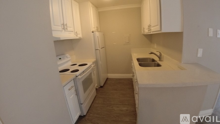 A kitchen with white appliances and cabinets.