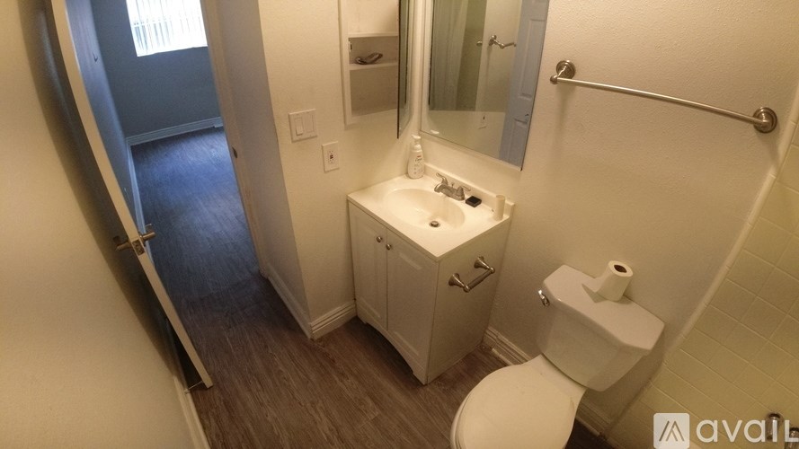 A bathroom with a toilet, sink, and mirror.