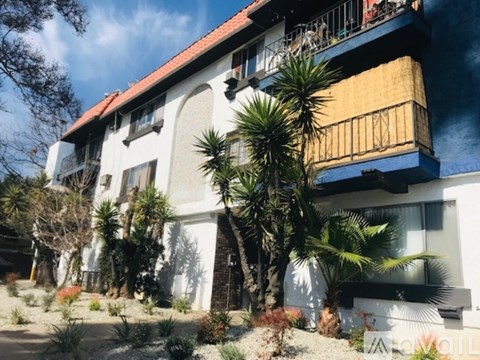 A white building with a red roof and balcony.