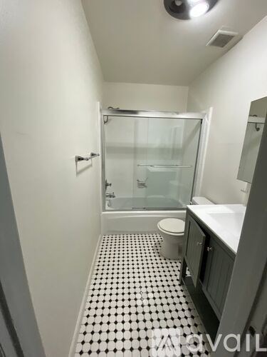 A bathroom with a toilet, sink and shower.