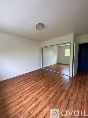 A room with wooden flooring and a white ceiling with a light fixture.