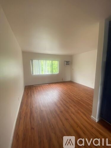 A room with wooden flooring and a window.