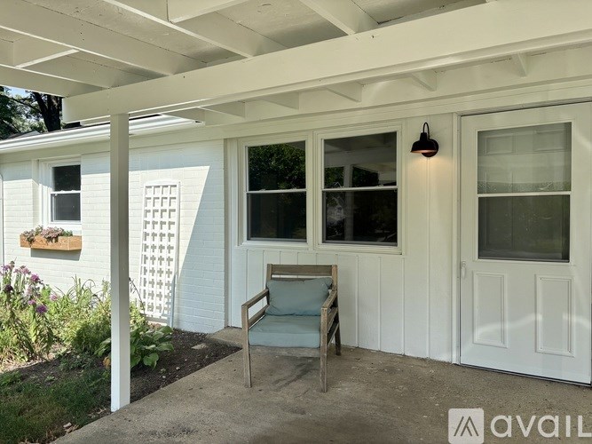 A white house with a porch and a chair.