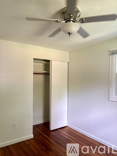 A room with a ceiling fan and a doorway.