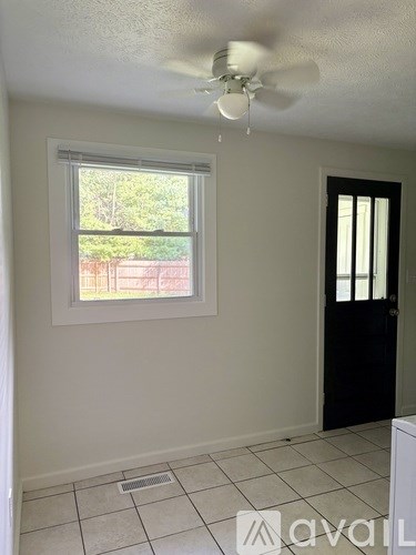 A room with a ceiling fan and a window.
