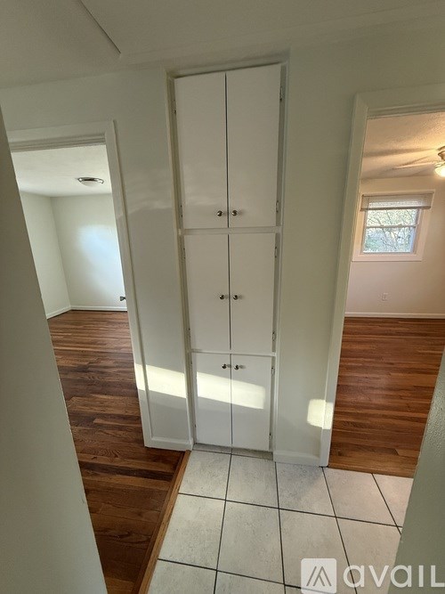 A kitchen area with a refrigerator, oven, and a window.