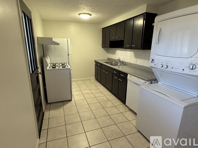 A small kitchen with a white dishwasher and a white washing machine.