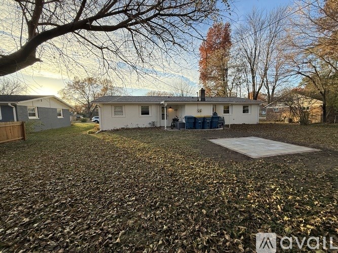A house with a driveway covered in leaves.