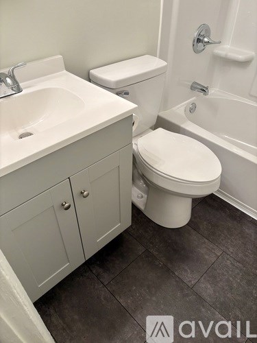 A white toilet sits next to a sink in a bathroom.