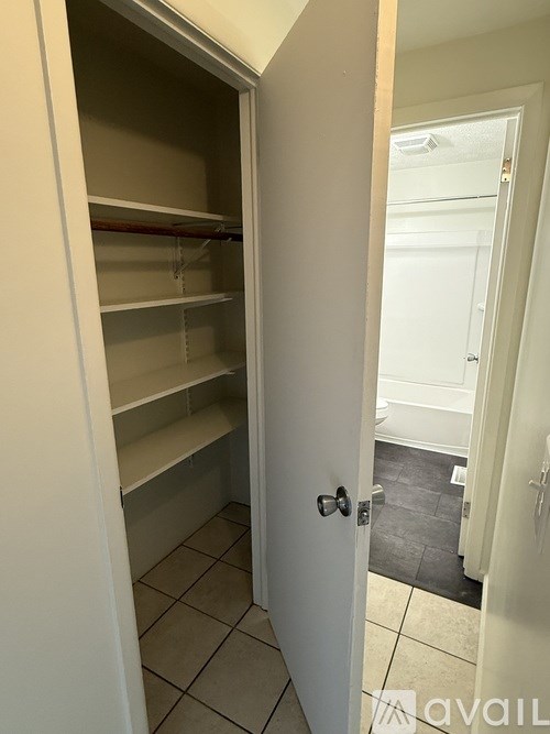 A room with a ceiling fan and two windows.