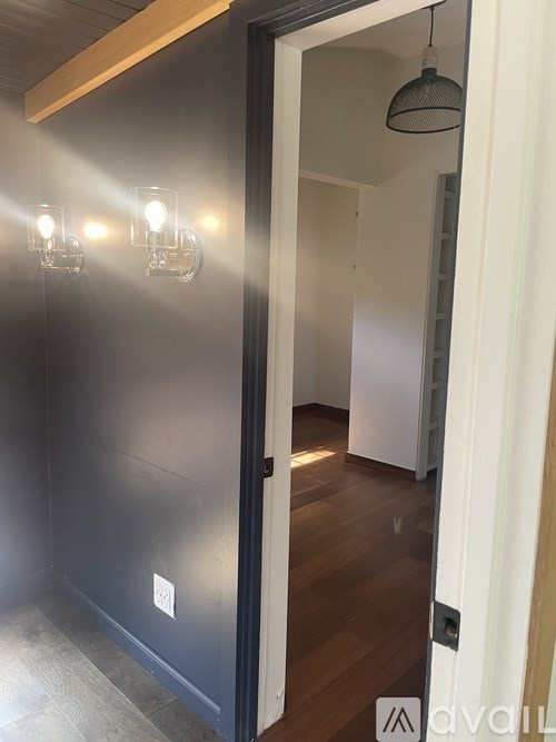 A hallway with a light switch and a light on.