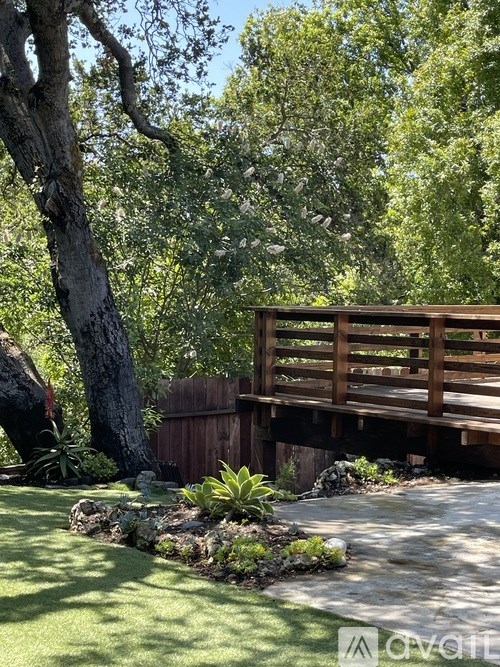 A wooden bridge over a small pond in a lush garden.