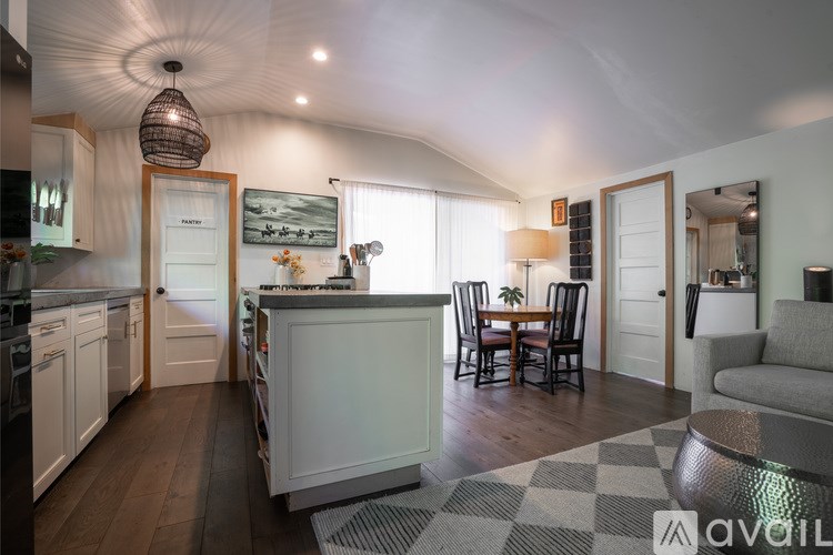 A modern kitchen with a dining area and a living room.