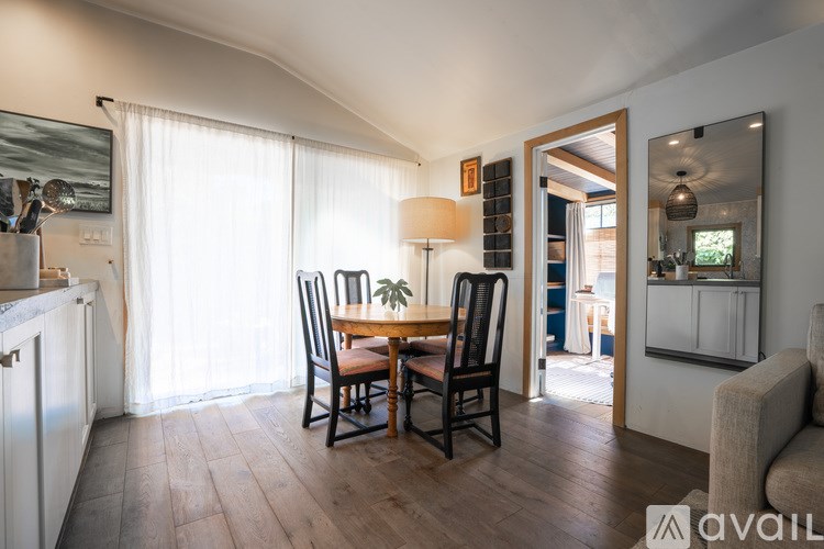 A dining room with a wooden table and chairs.
