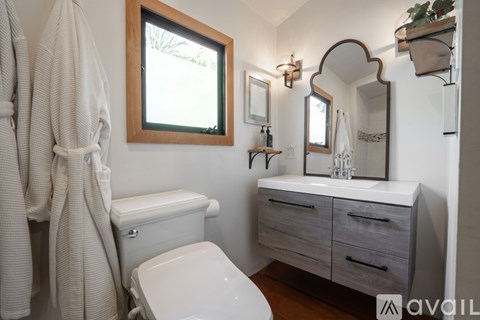 A white toilet with a white towel hanging on the wall.