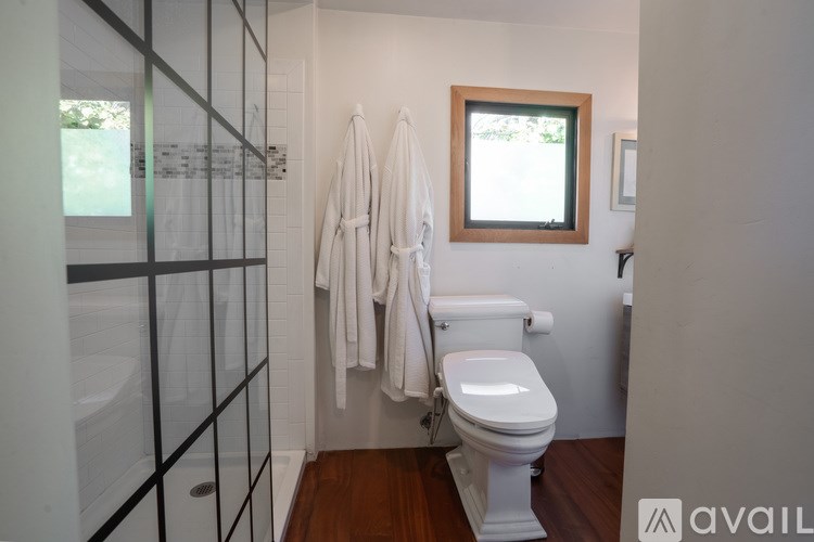 A white toilet in a bathroom with a window and a towel rack.