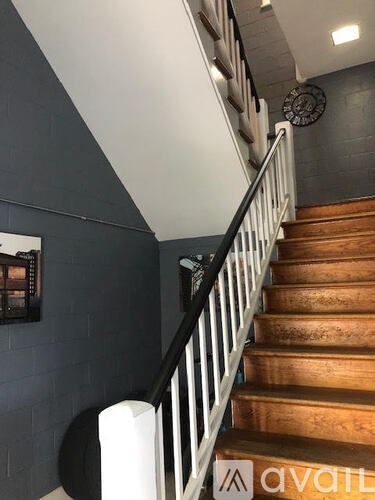 A staircase with a black railing and wooden steps.