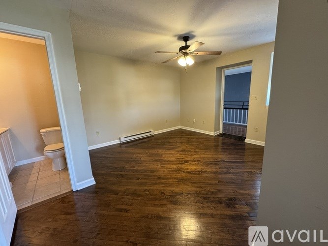 A room with wooden floors and a ceiling fan.
