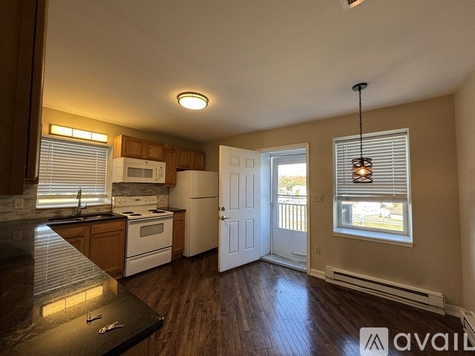 A kitchen with wooden floors and a black countertop.