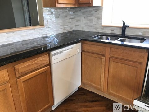 A kitchen with wooden cabinets and a white dishwasher.