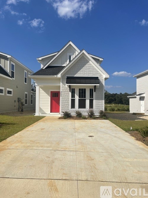 A house with a red door is in front of other houses.