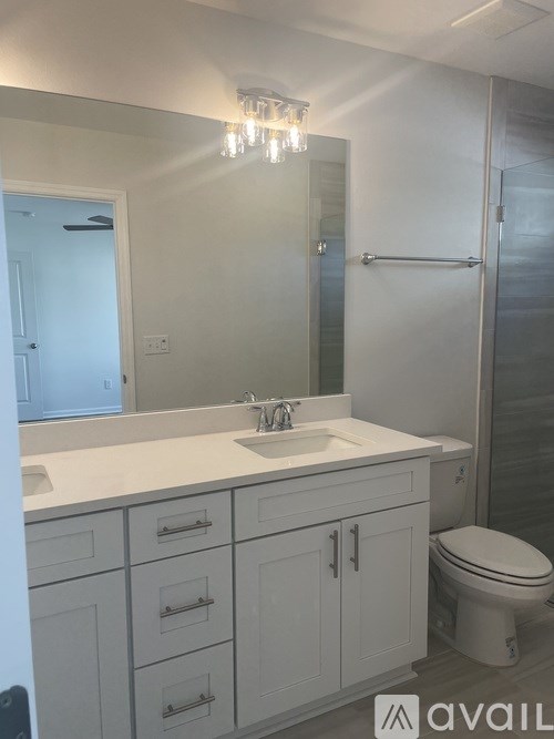 A bathroom with a white sink and toilet.