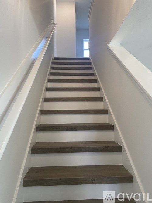 A set of stairs with alternating light and dark wooden steps.