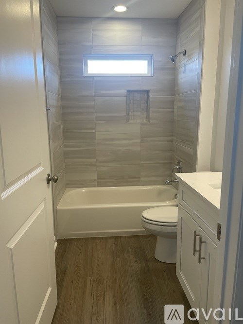 A bathroom with a tub, toilet and sink.