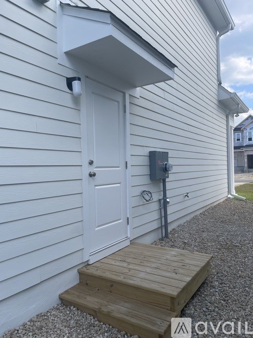 A white door with a small window above it and a mailbox to the right.