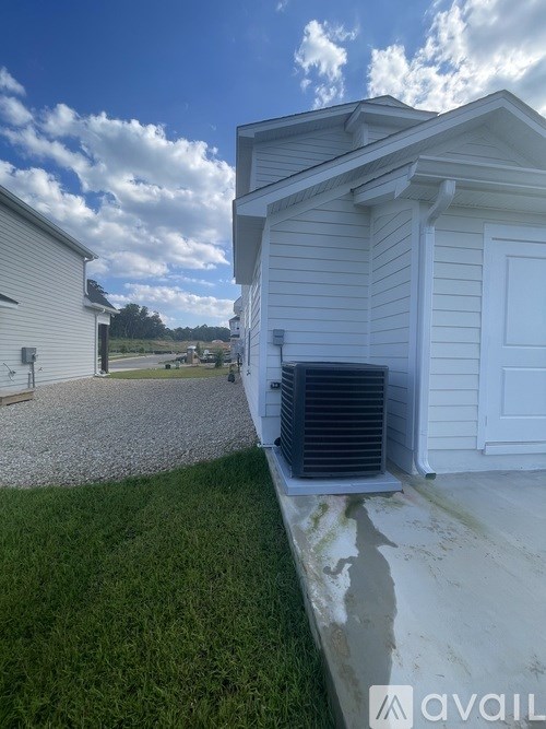 A house with a white garage door and a blue air conditioning unit.