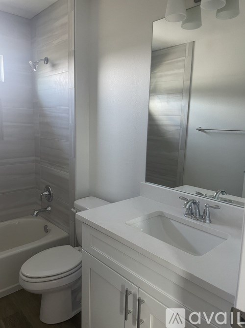 A white bathroom with a toilet, sink, and bathtub.