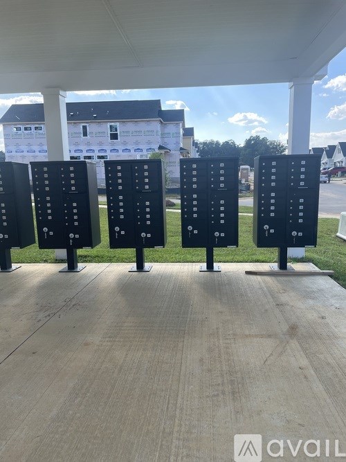 A row of parking meters are lined up on a concrete slab.