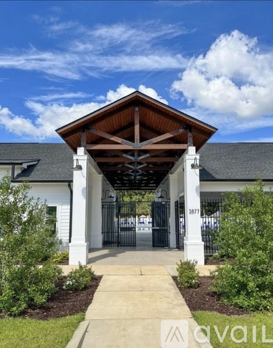A white building with a black roof and a wooden overhang.