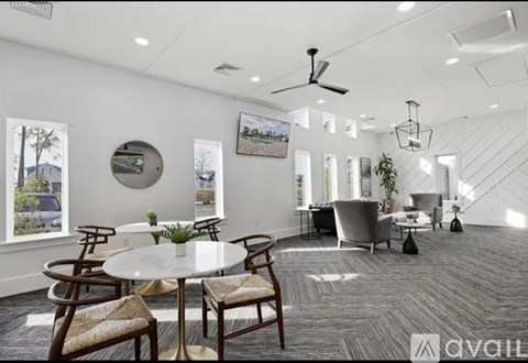 A spacious living room with a dining table and chairs.
