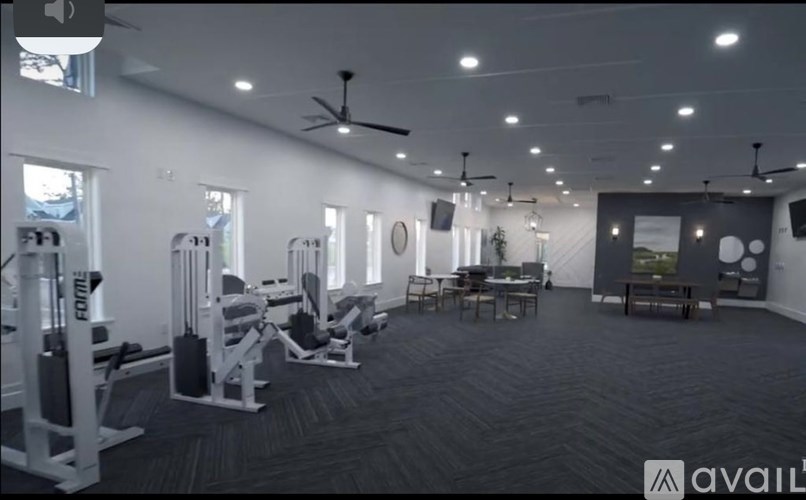 A gym with a variety of equipment including weights and cardio machines.