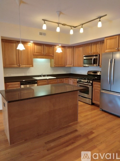 A kitchen with wooden cabinets and a black countertop.