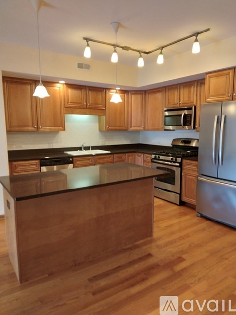 A kitchen with wooden cabinets and a black countertop.