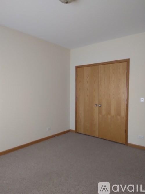A room with a wooden door and carpeted floor.