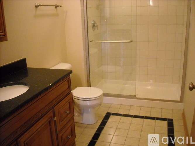 A bathroom with a toilet, sink, and shower.
