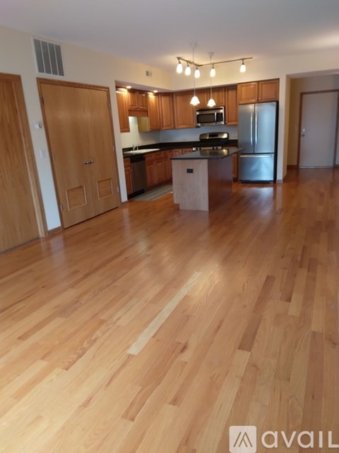 A kitchen with wooden floors and cabinets.