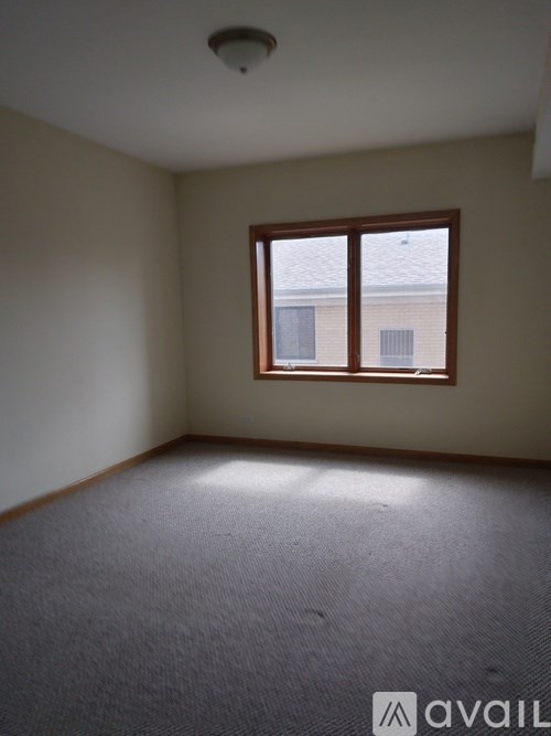 A room with a carpeted floor and a window.