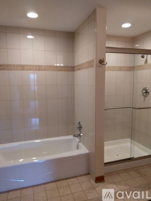 A bathroom with a white bathtub and a glass shower door.