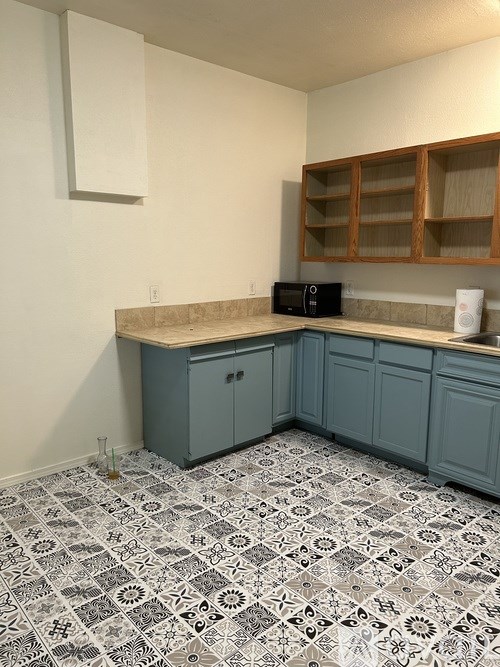 A kitchen with a black stove top oven and a white counter top.