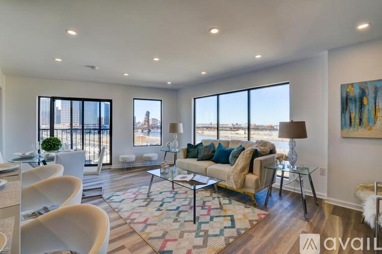 A living room with a couch, chairs, and a rug.