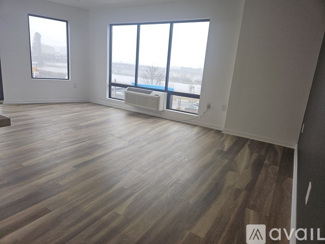 A room with wooden flooring and large windows overlooking a snowy landscape.