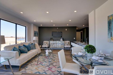 A modern living room with a white sofa and a glass coffee table.